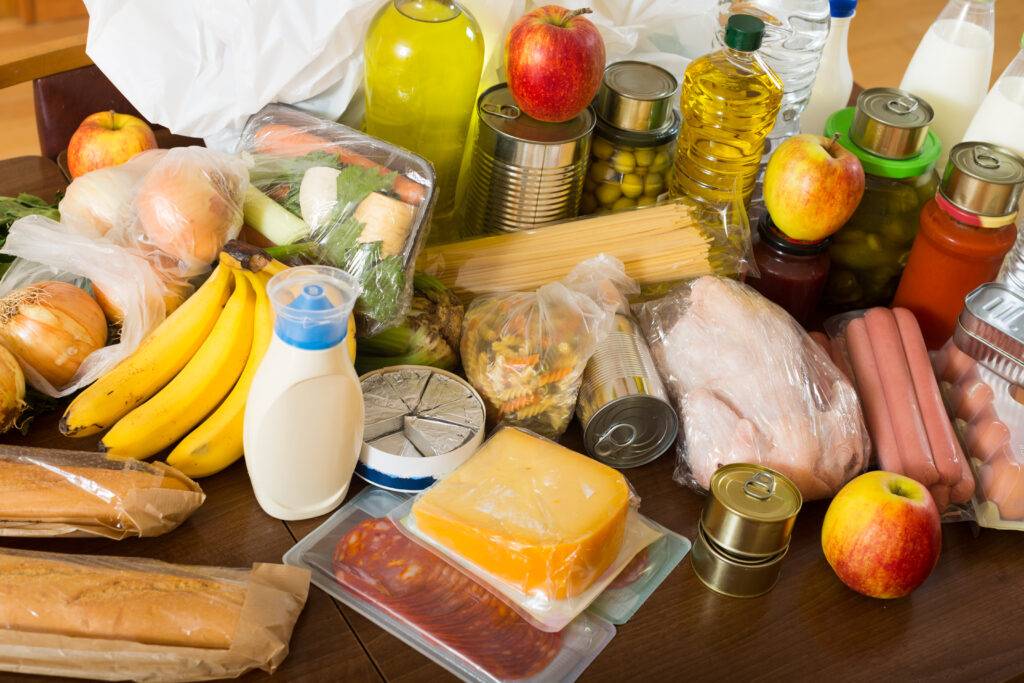 A close-up of a grocery receipt, fresh produce, and a reusable shopping bag on a clean kitchen counter. The image conveys savings, organization, and reliable personal service.